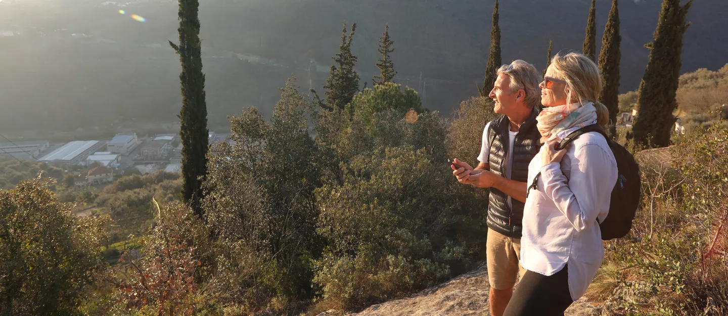 A man and woman hiking on the side of a mountain