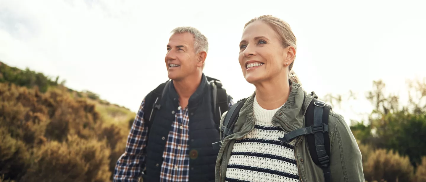 Couple hiking outdoors on a sunny day with backpacks