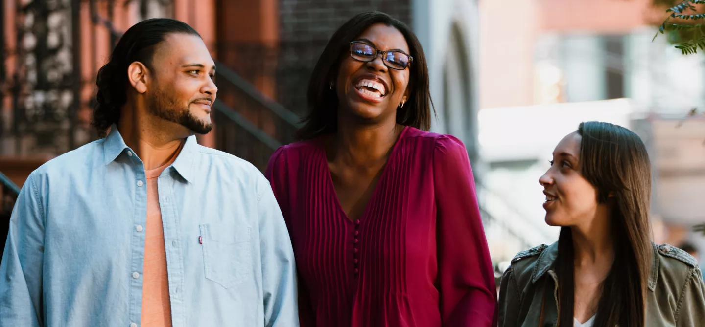 Erica and her friends laughing outside on a city sidewalk.