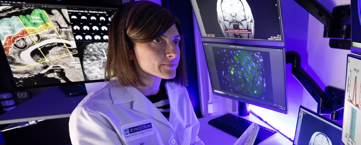 A physician in a lab looking at a computer
