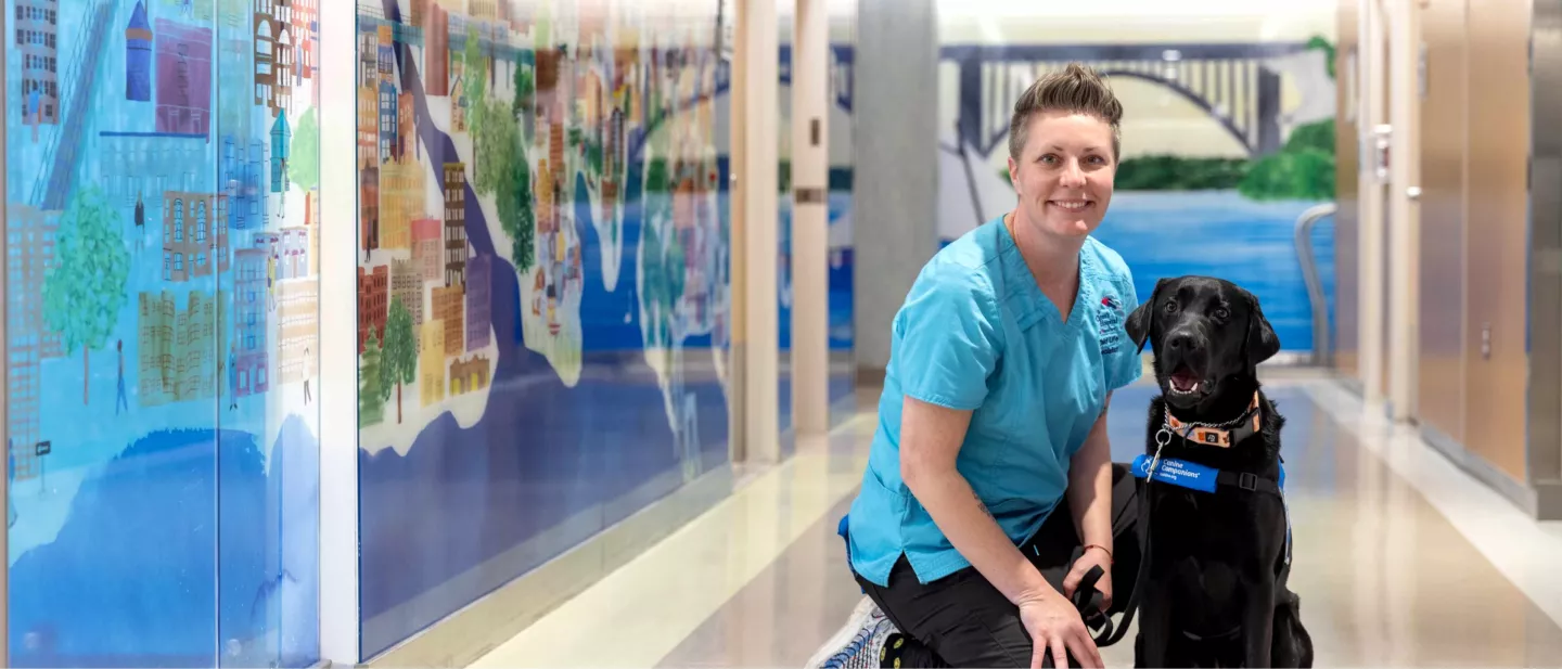 Polly the black labrador and handler posing for picture