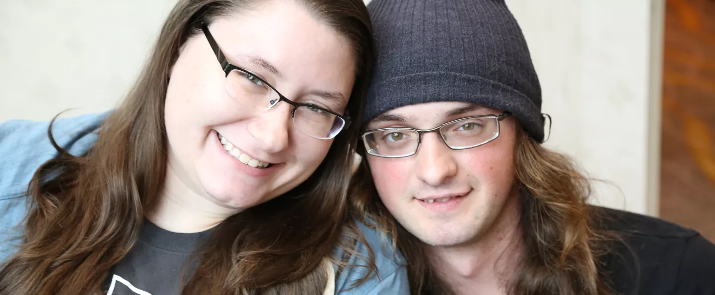 A young man and woman sitting together, smiling