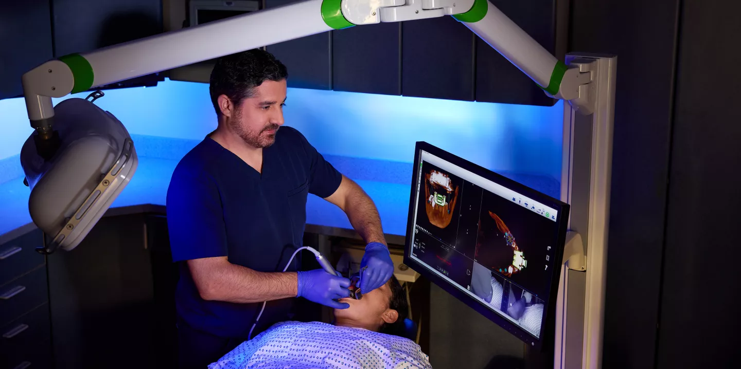 Dr. Nolan using equipment to look at imagery of a patient's mouth.