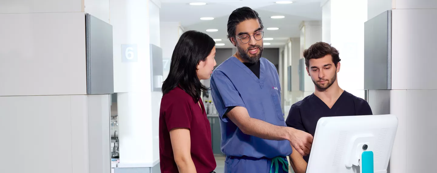 Dr. Ahmed alongside two young medical professionals.