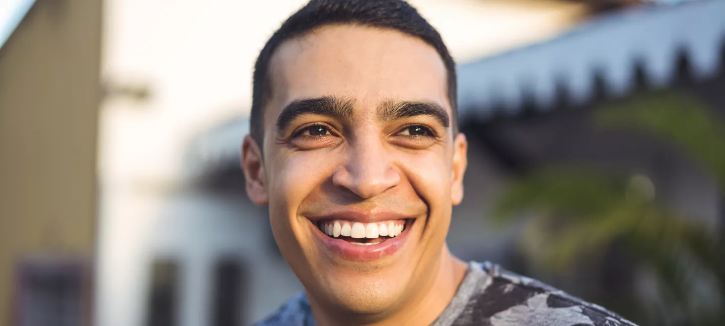 Close-up of a cheerful man smiling in the sunlight outdoors