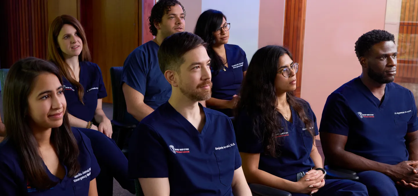 Group of emergency medicine residents attentively participating in a classroom lecture or training session.