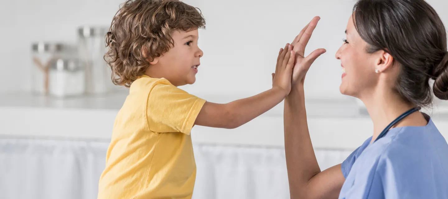Friendly nurse giving a high-five to a young boy