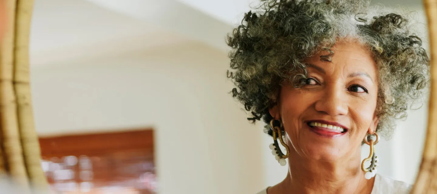 Woman smiling looking at her reflexion in the mirror
