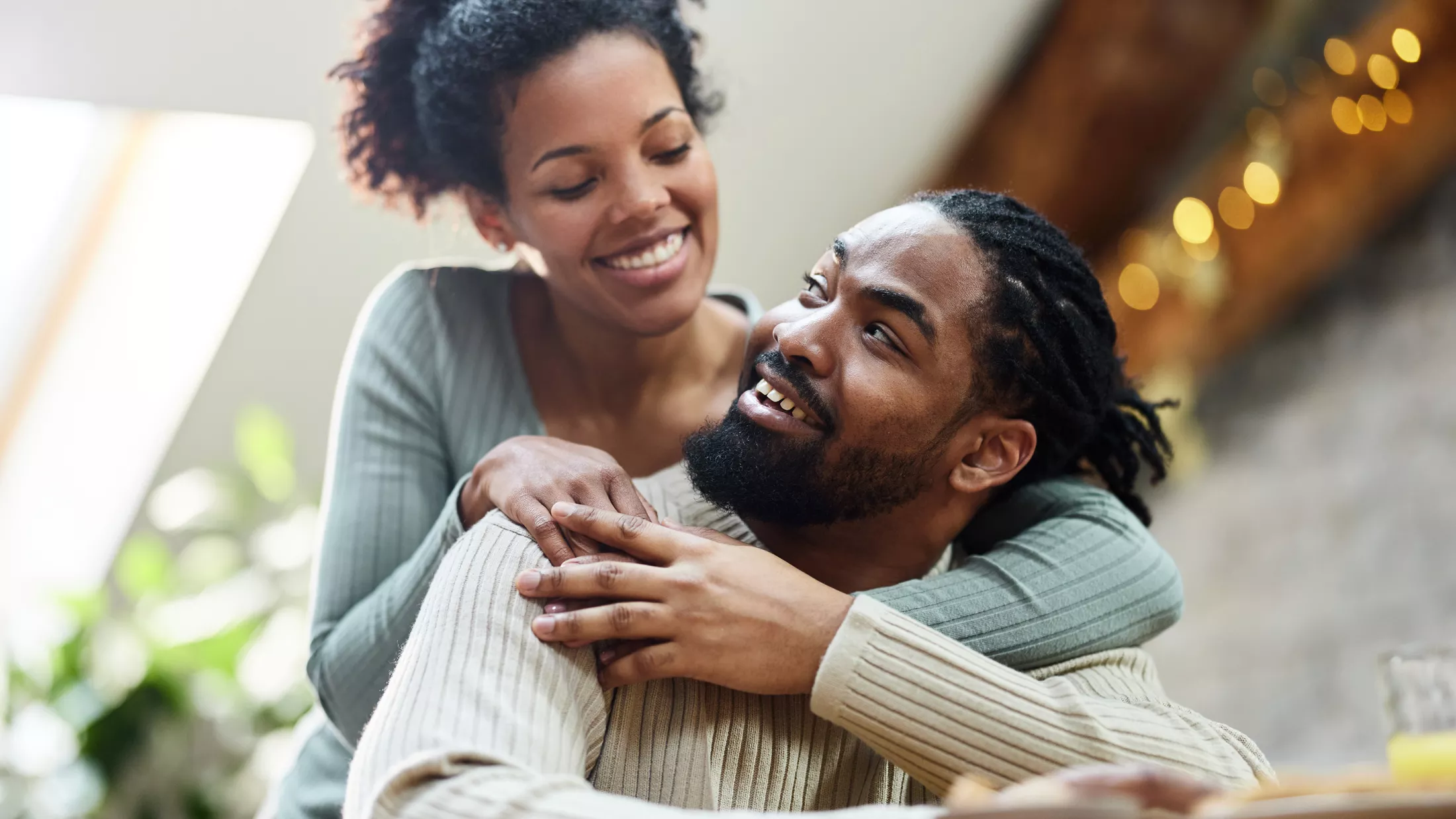 A happy couple embracing inside their home