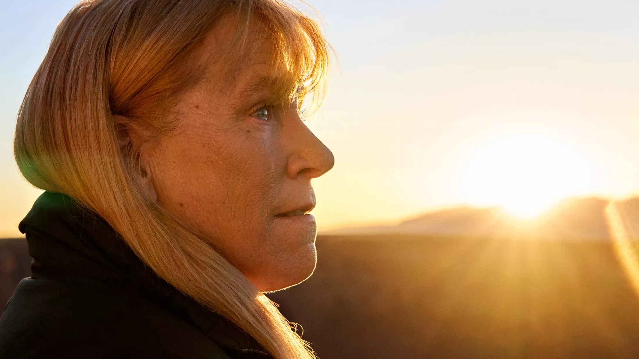 Barbara looking outside in front of the setting sun