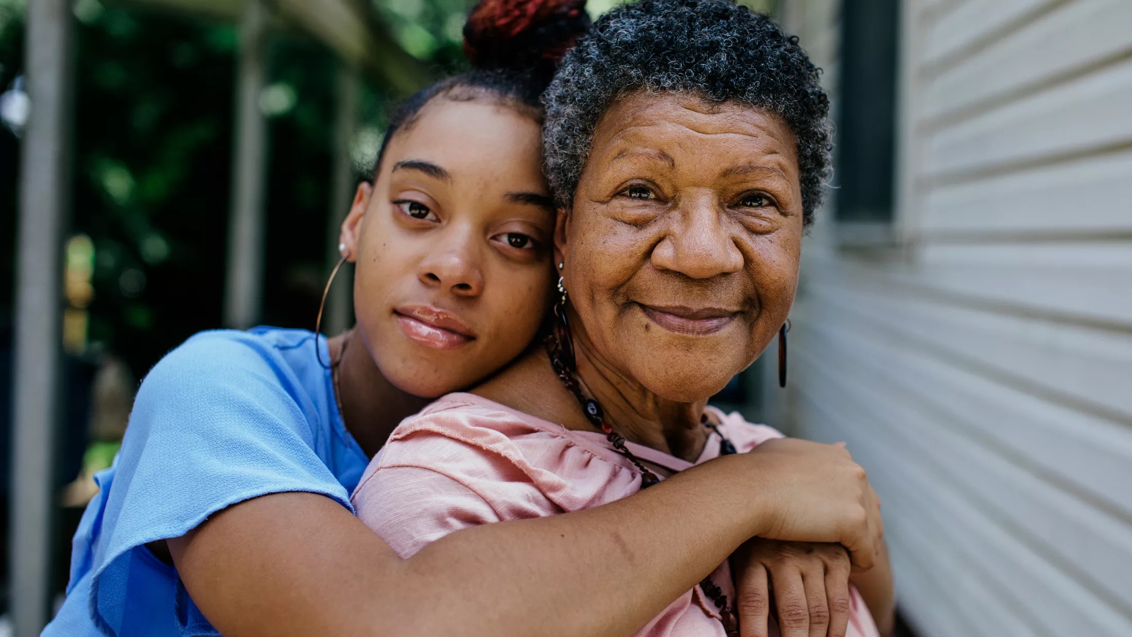 A grandmother and teenage grandaughter hugging