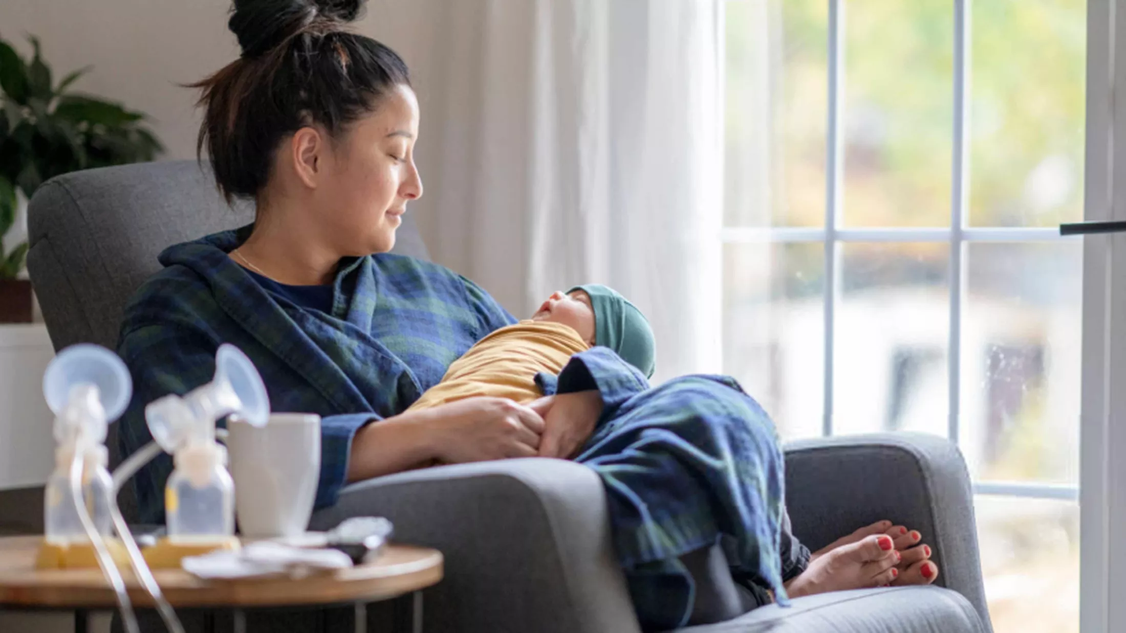 Mother sitting in couch looking at her baby