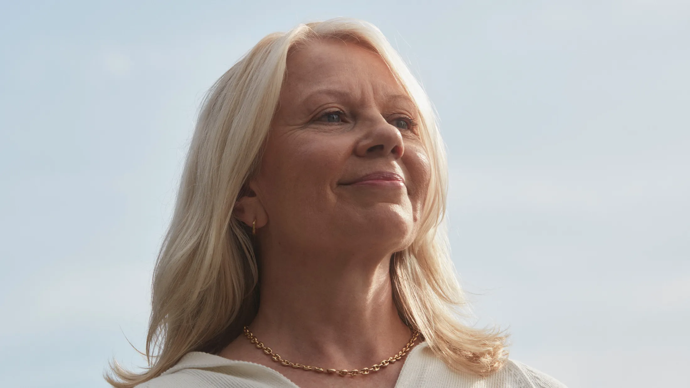 Senior woman smiling confidently with clear sky background