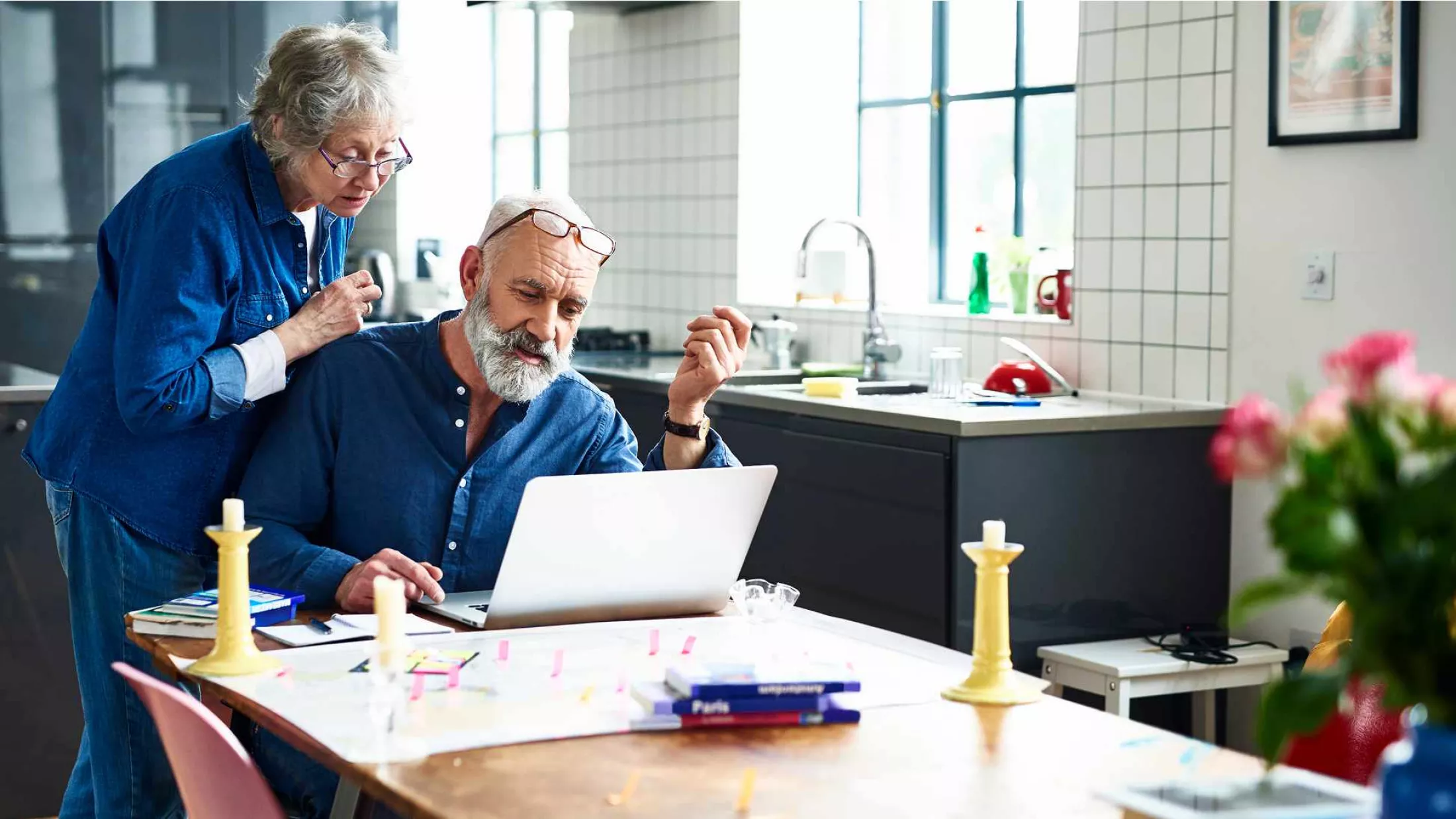 Two elderly people looking at laptop screen