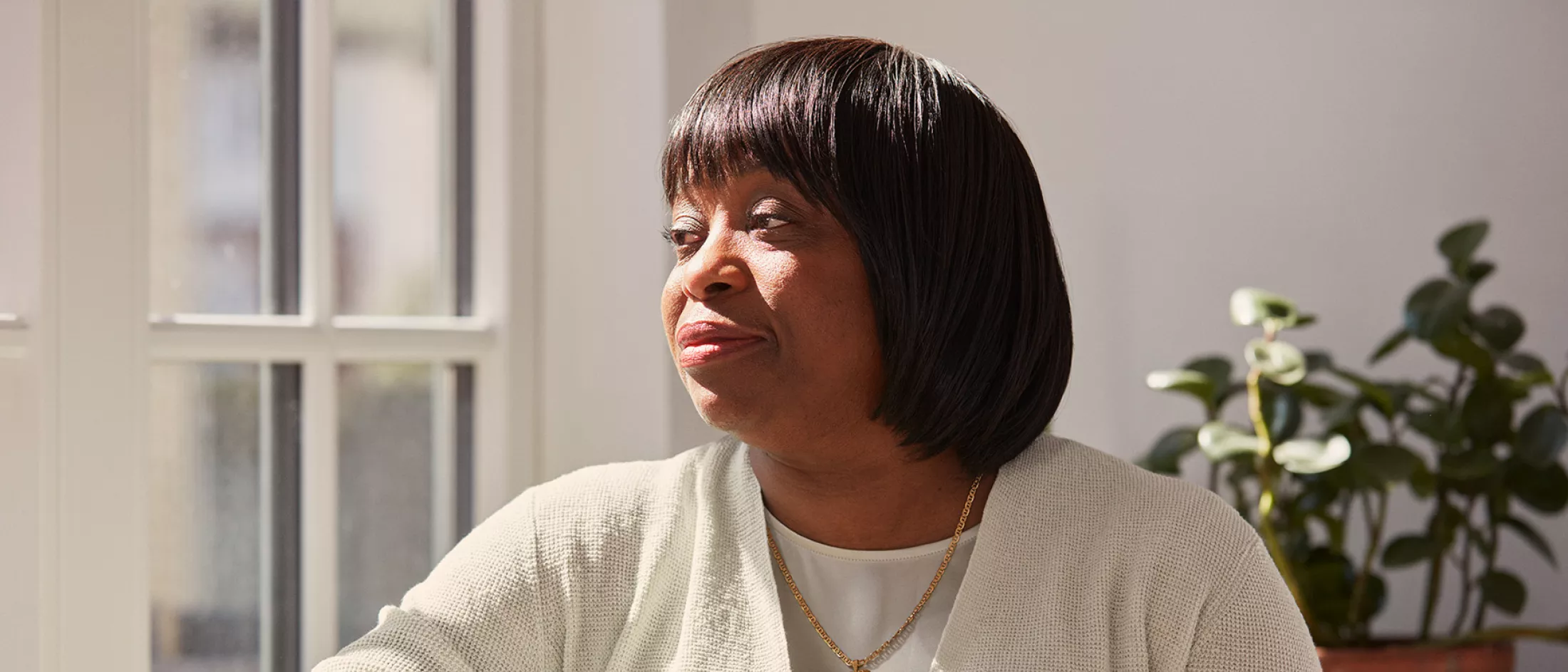 Adult sitting at table with coffee mug.