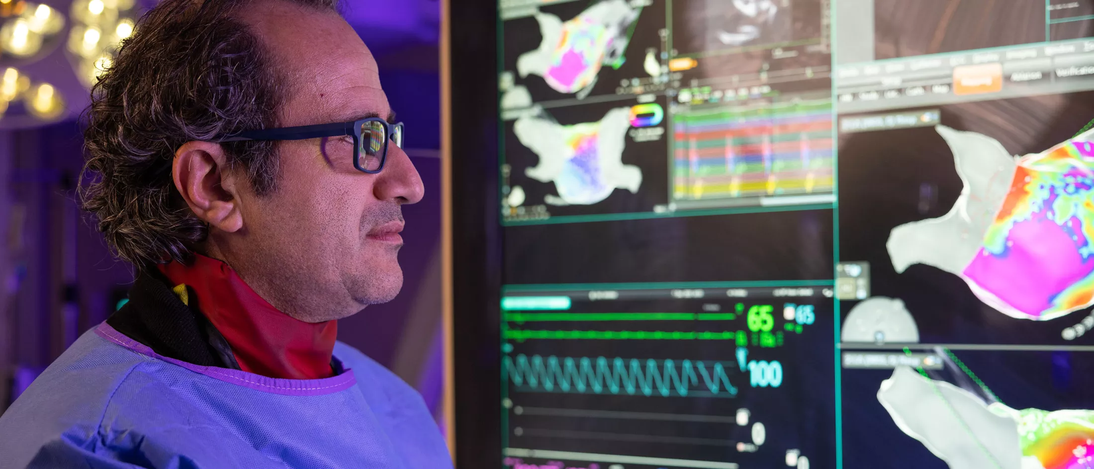 A physician in a lab looking at monitors