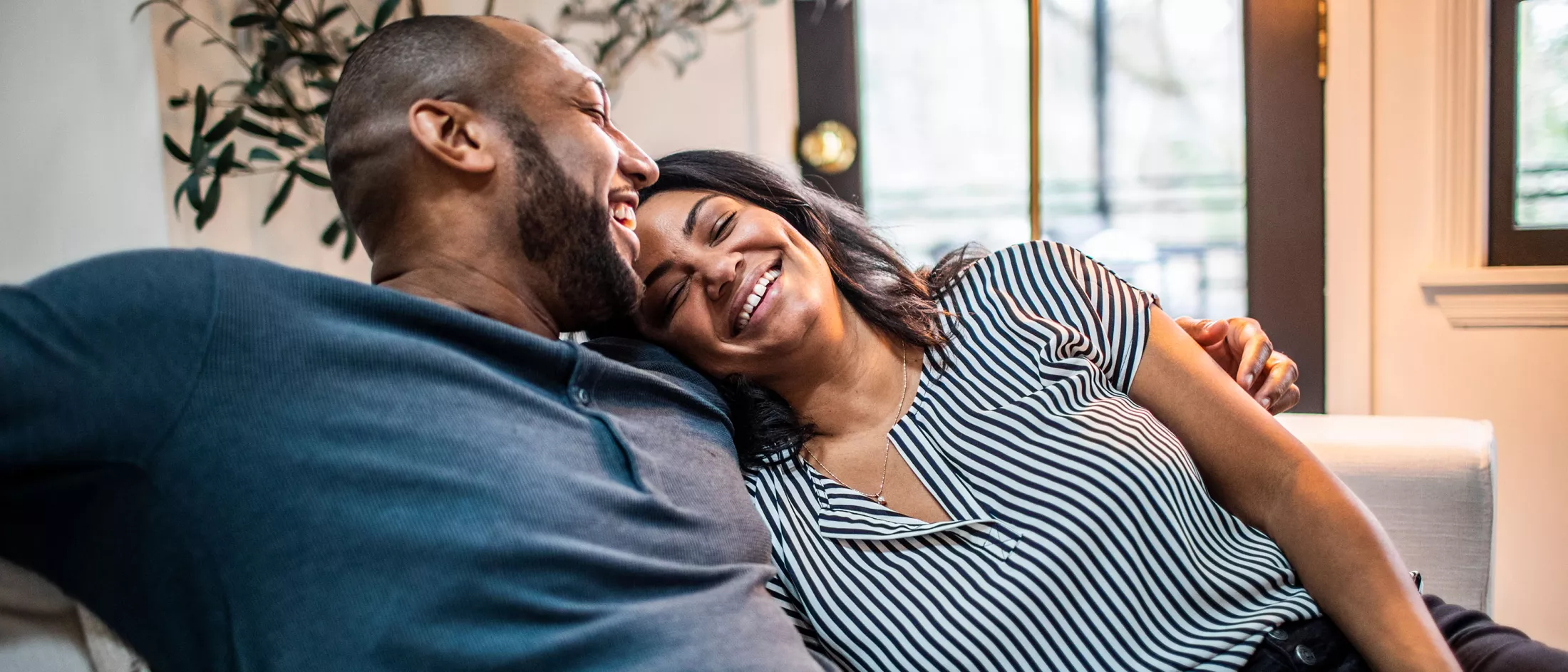 A man and a woman embracing on a couch