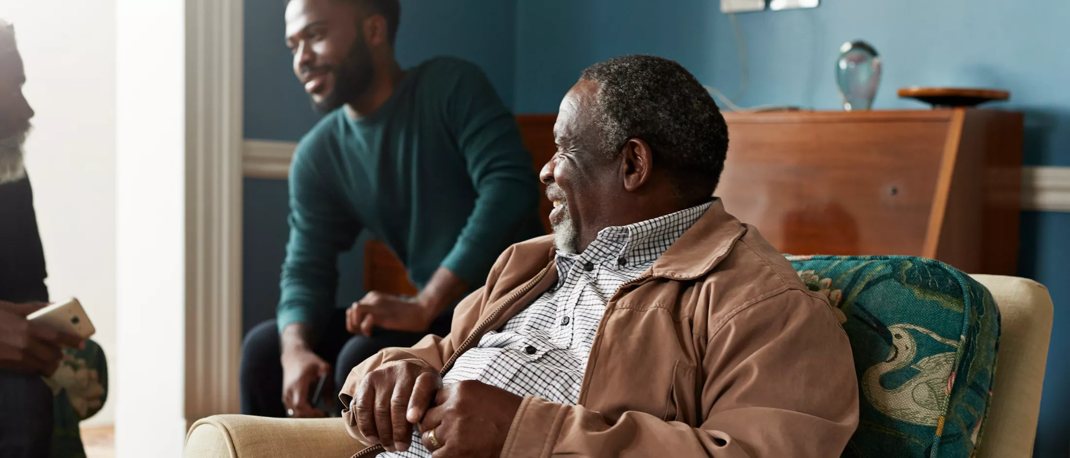 Man looking at friends talking while sitting in living room.
