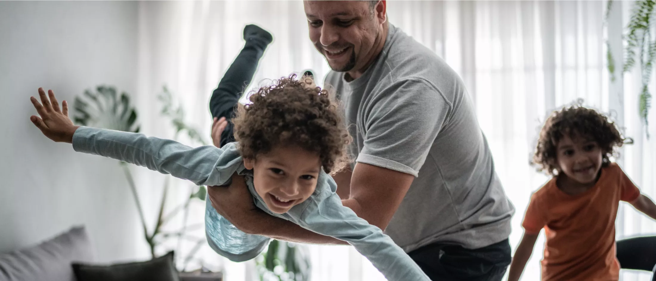 Family playing at home in sunny living room