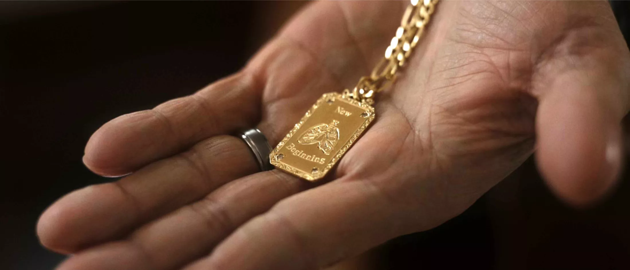 Paul's hand showing his New Beginning pendant