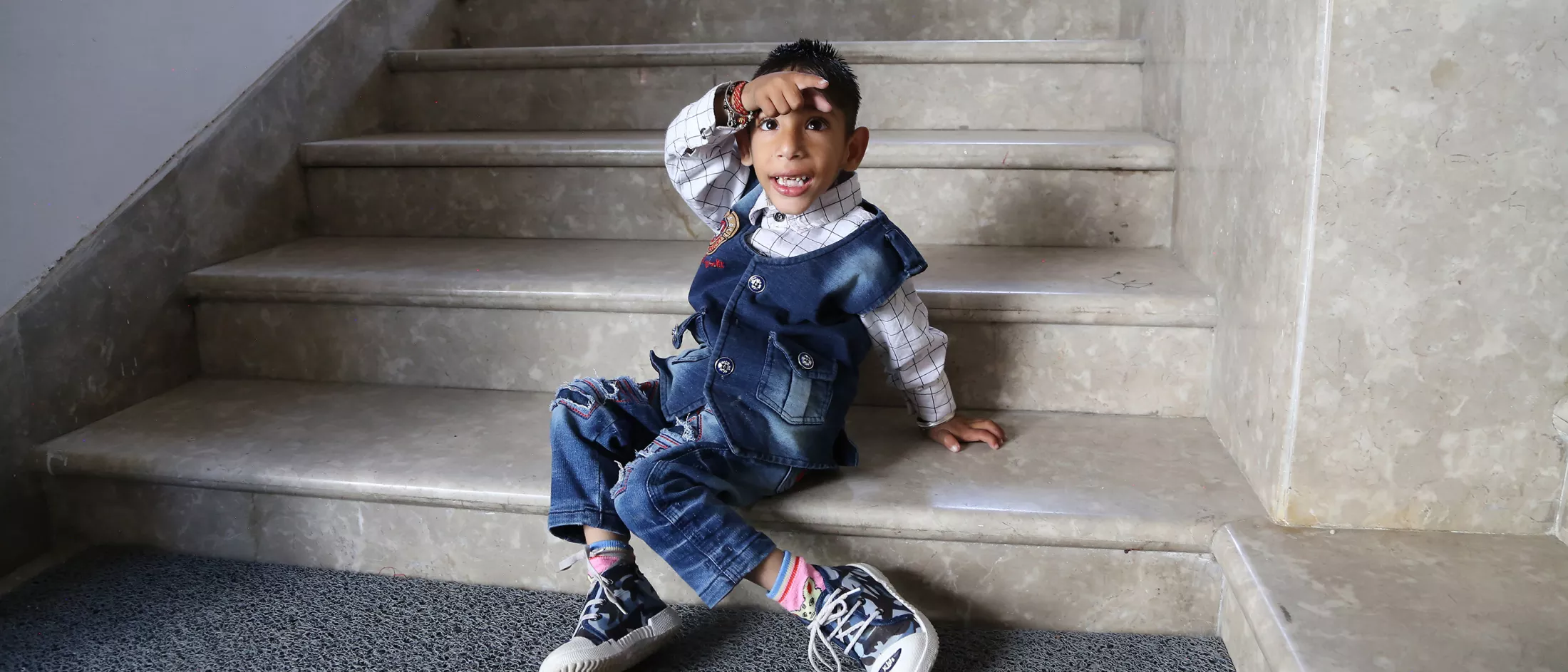 A young child sitting on steps