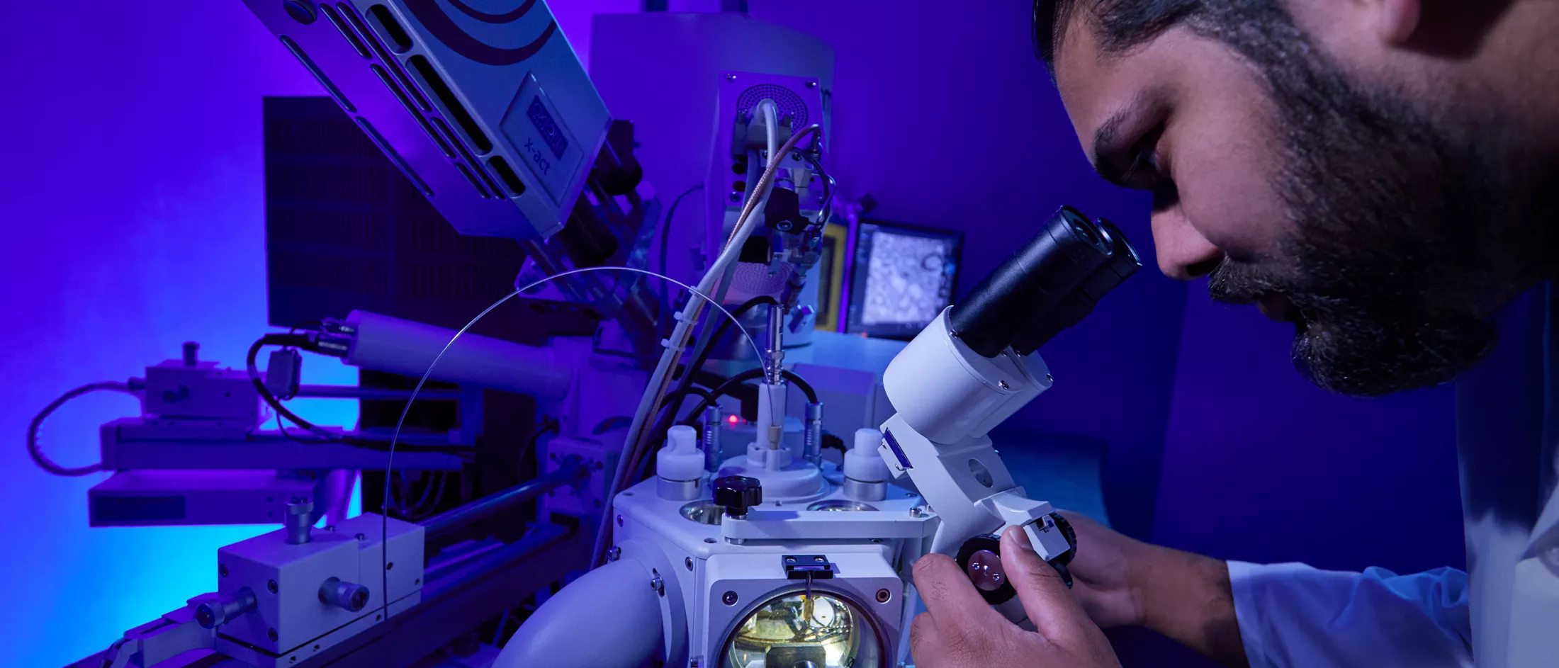 A researcher looking through a micrscope in a laboratory 