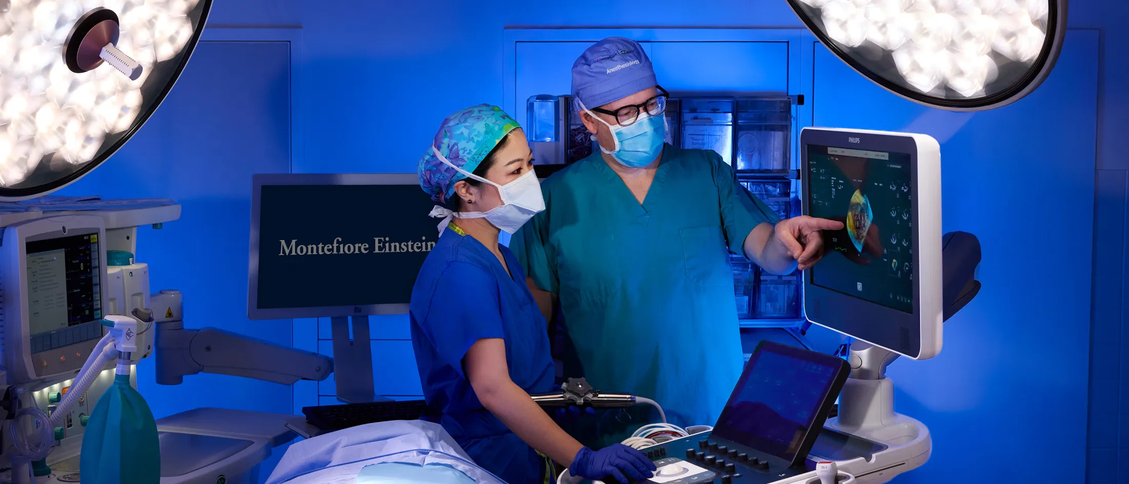 Clinicians review cardiac ultrasound on monitor in surgical room.
