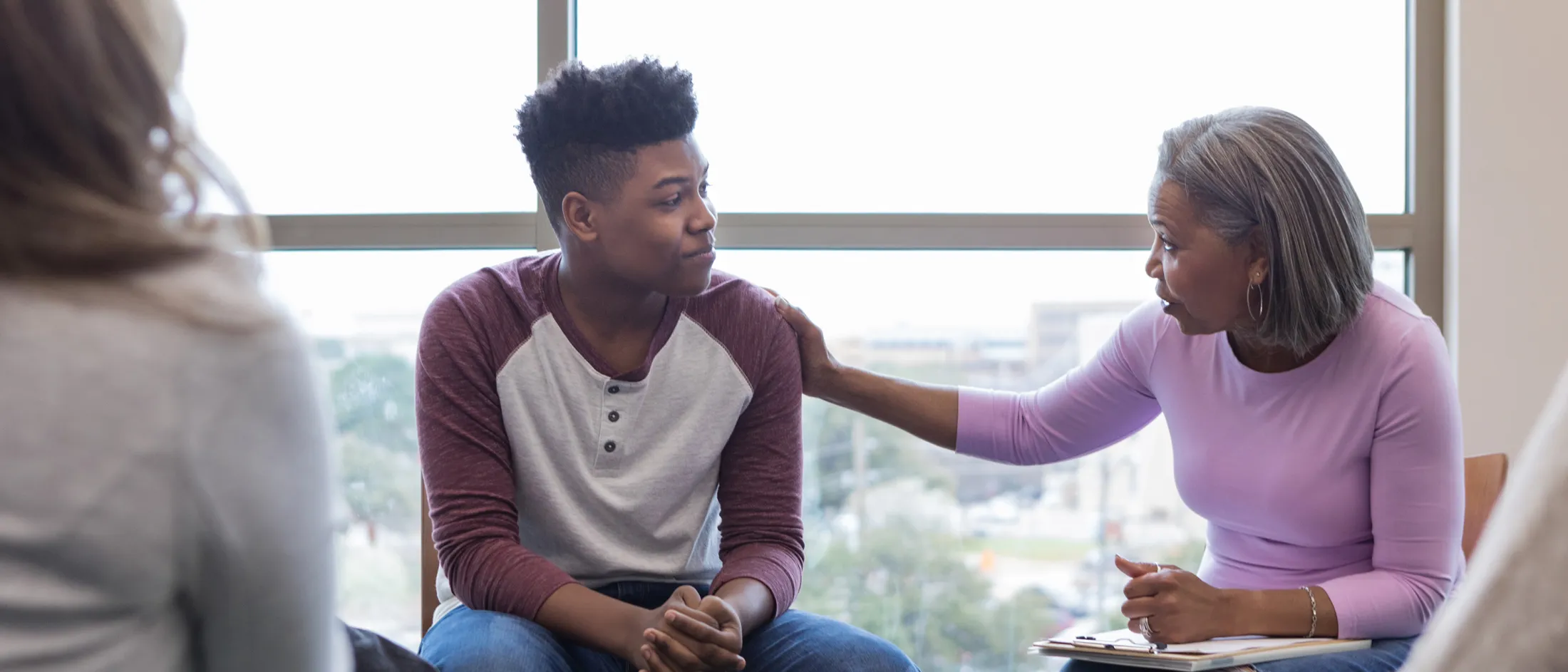 Therapist speaking gently to young man during counseling session