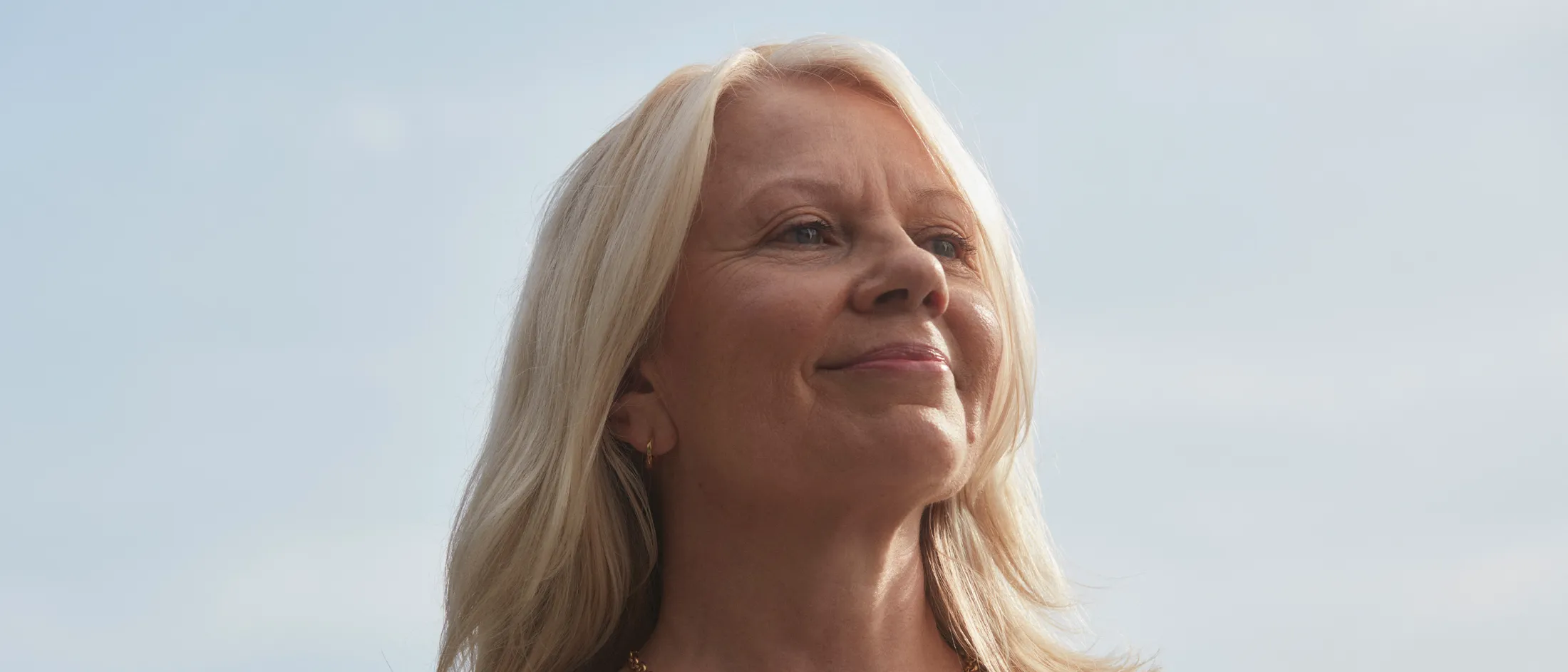 Senior woman smiling confidently with clear sky background