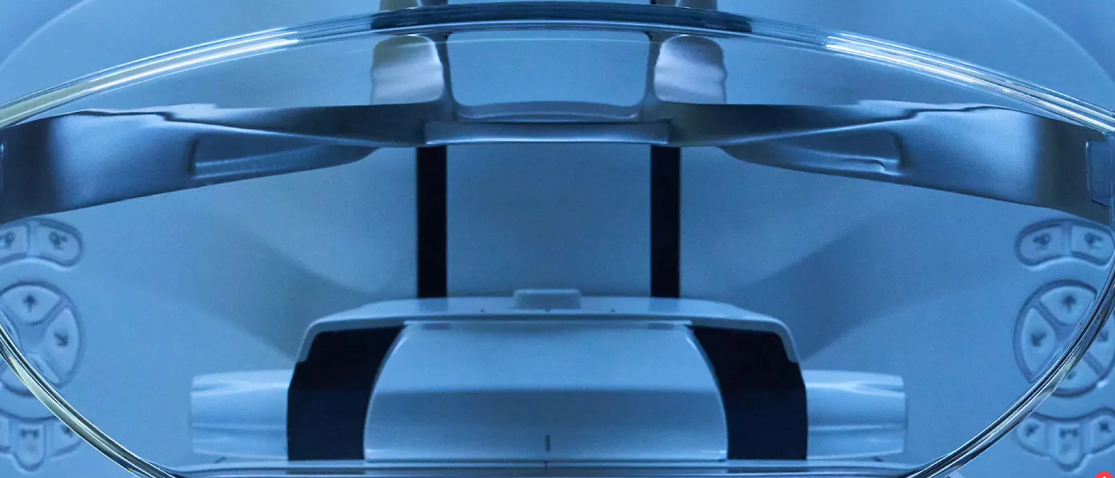 Close-up of a modern medical imaging machine with blue lighting, viewed from the patient’s perspective.