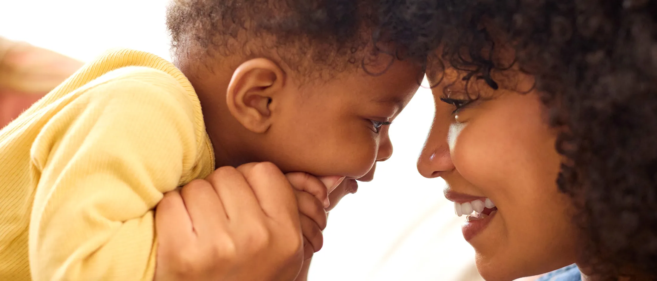 A woman and baby smiling at each other lovingly 