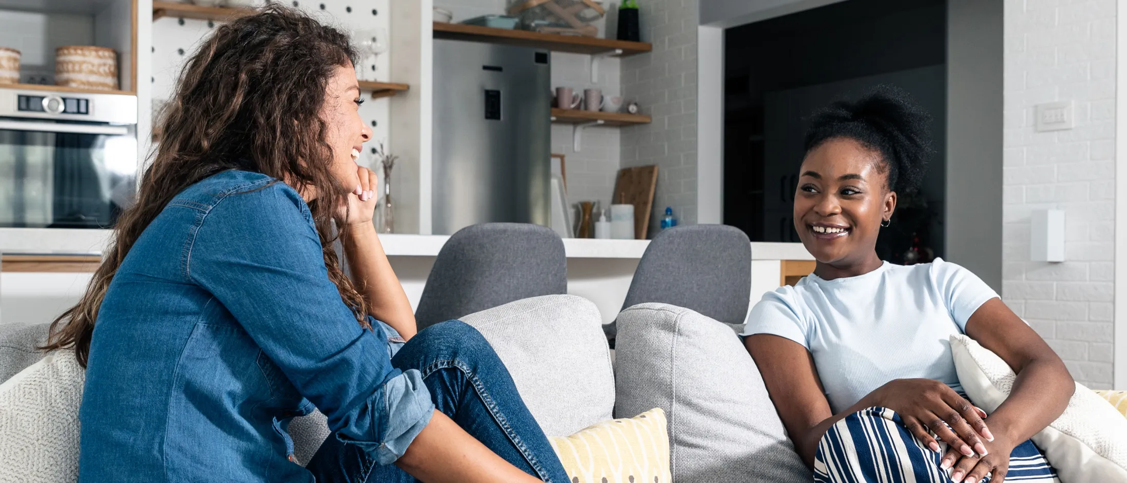 Two women sitting on a couch having a heartfelt conversation