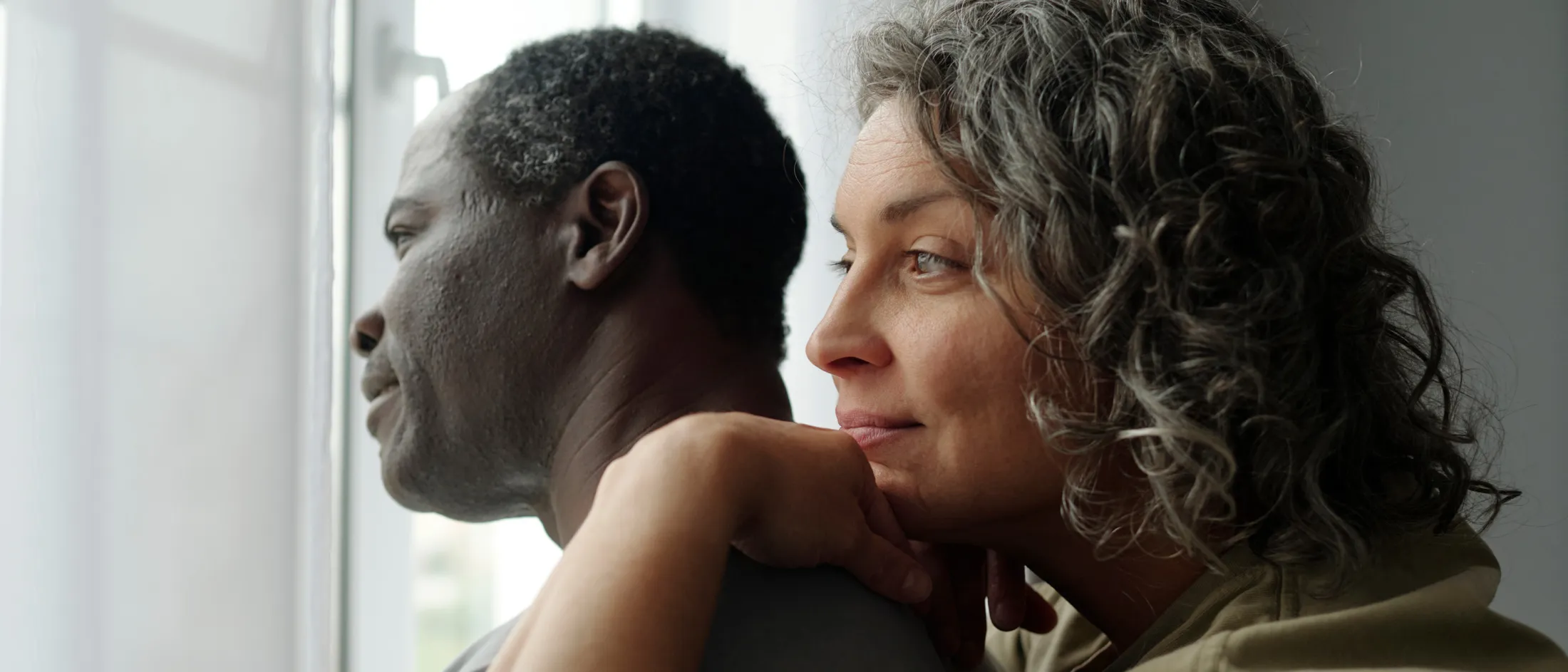 Couple standing together looking out a window