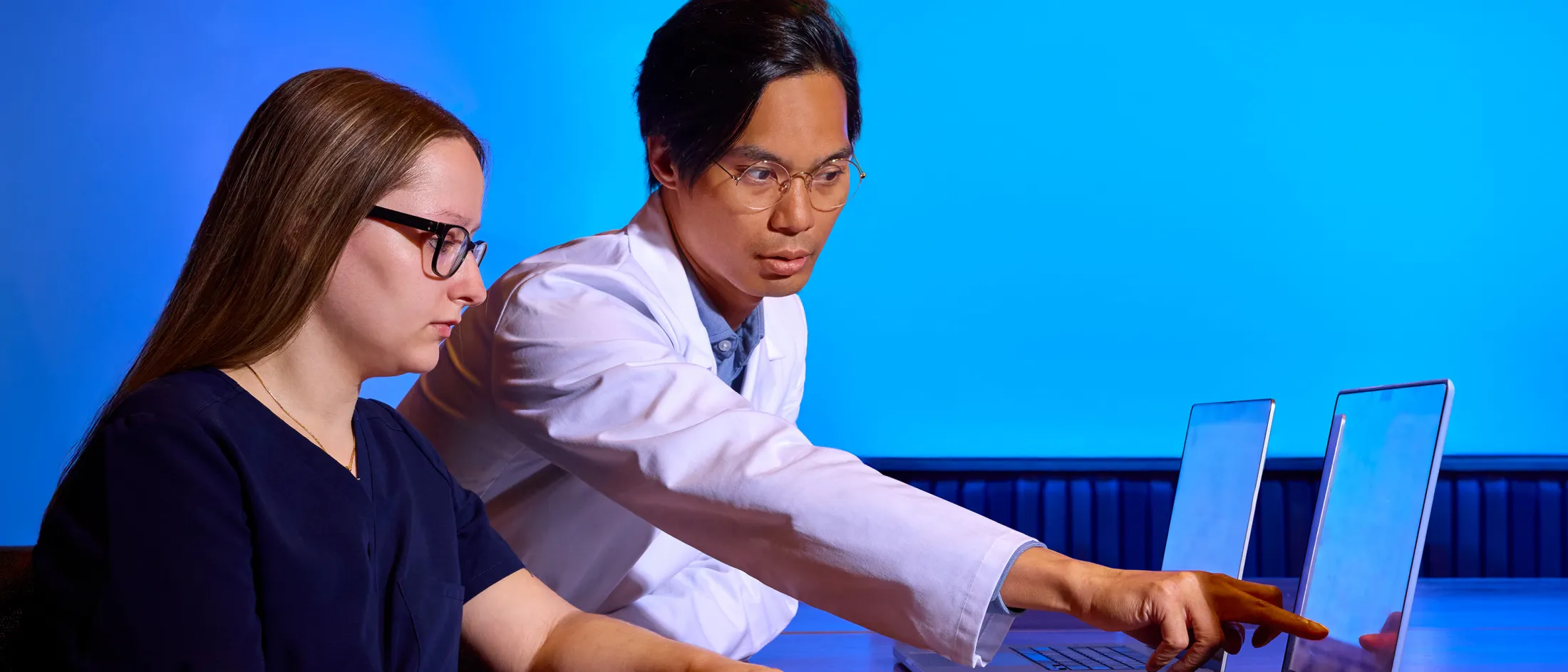 Montefiore physician in a white coat points to a digital asthma education module while speaking with a patient.