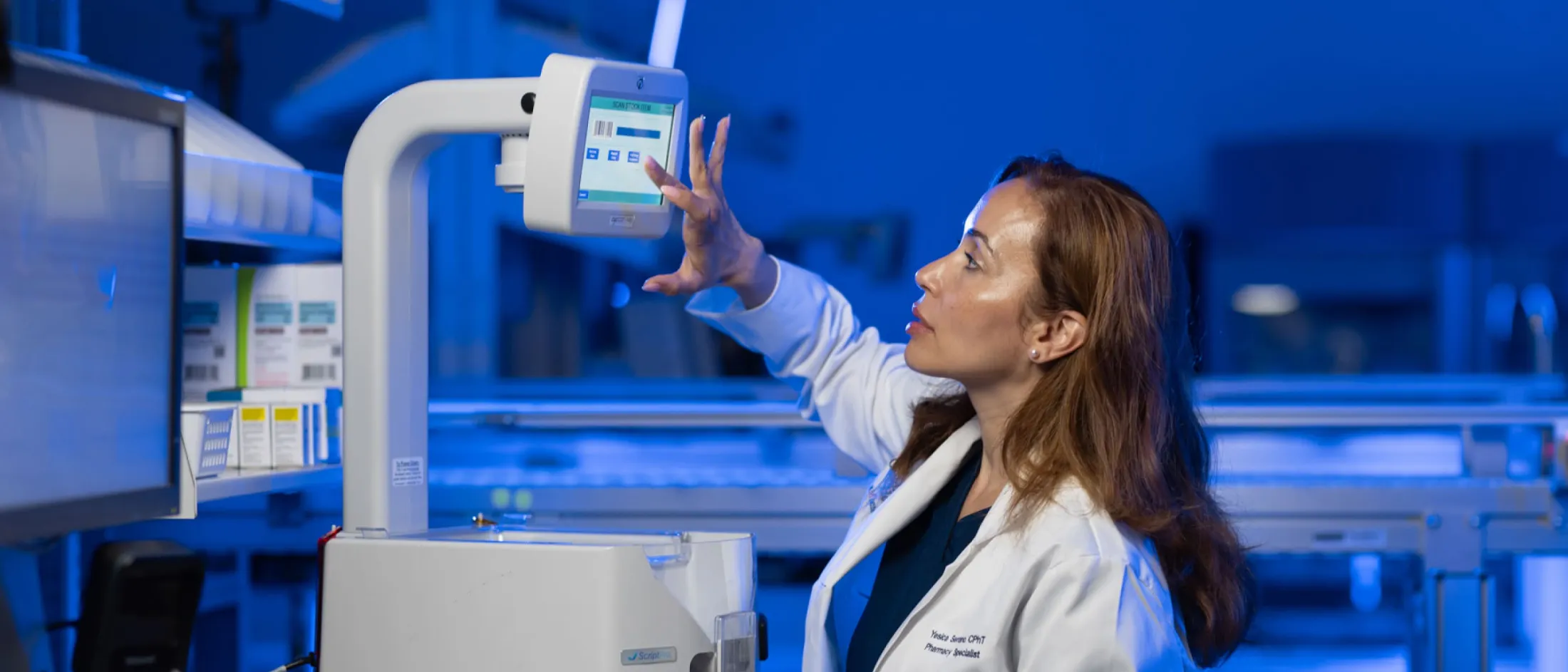 Lab tech tapping scanner screen with finger