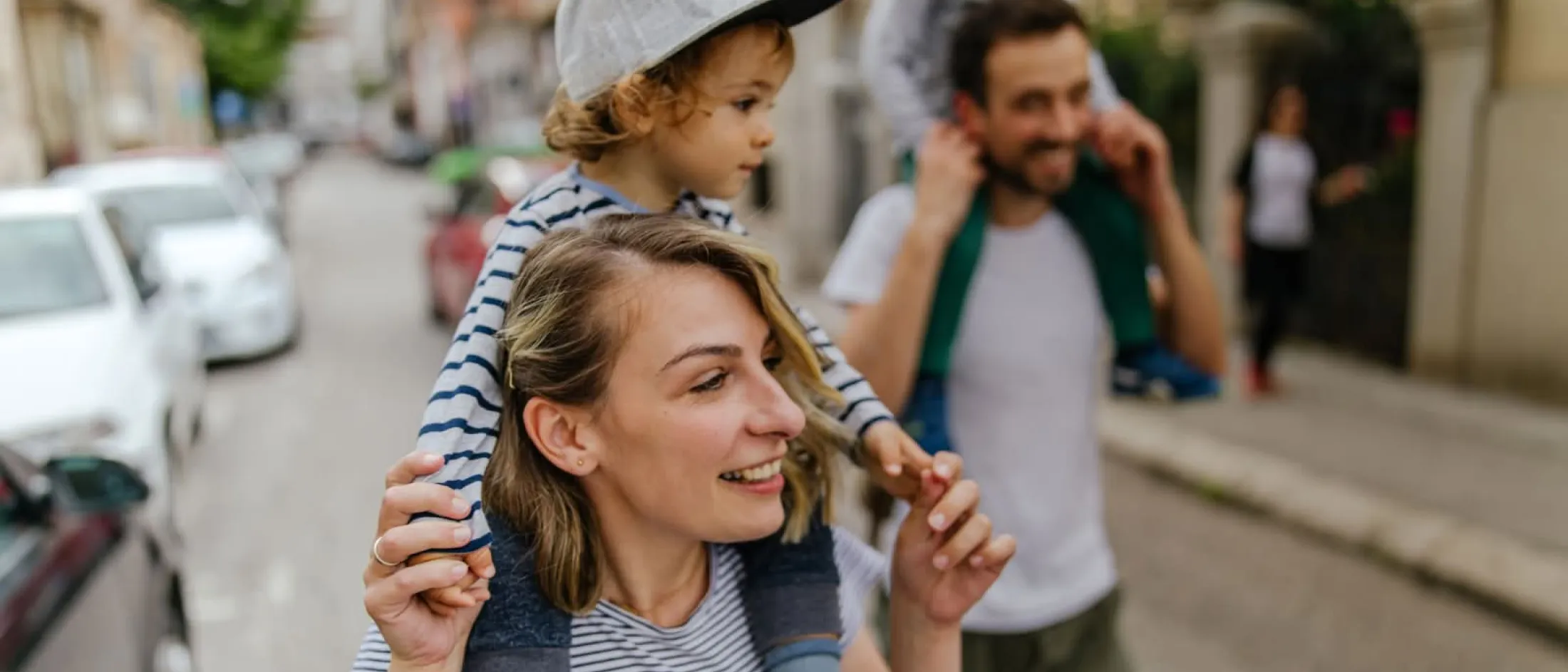Mom and dad walking with their kids on their shoulders