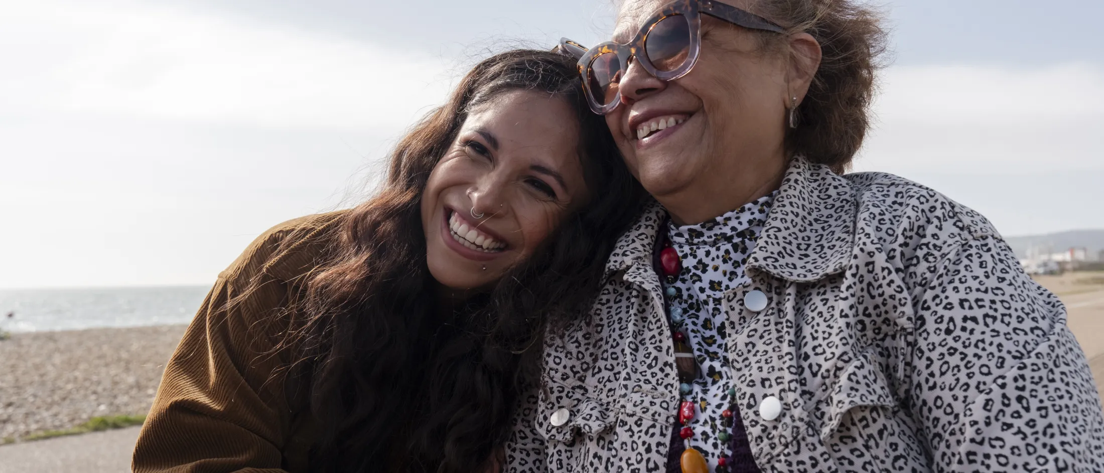 Joyful moments between two women enjoying a sunny day by the beach