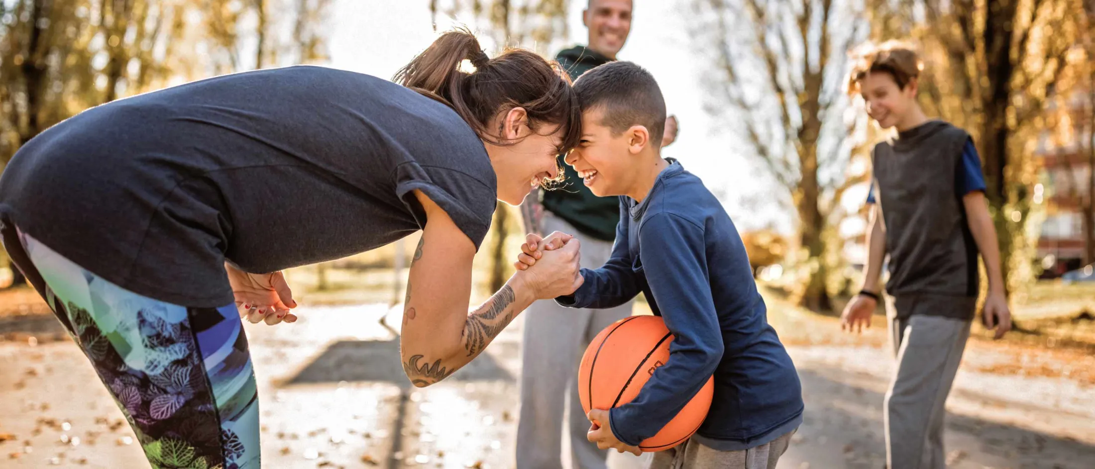 Family playing basketball in the park.