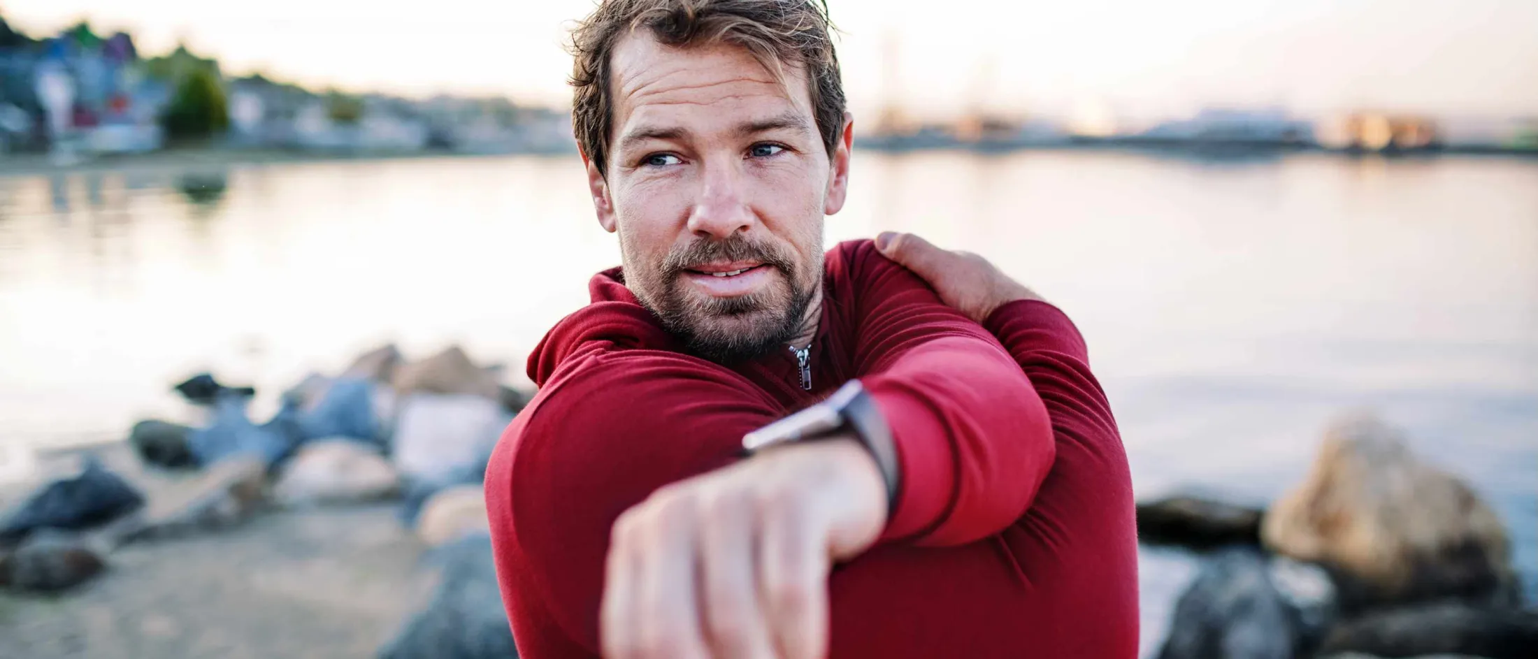 Man stretching by the shore