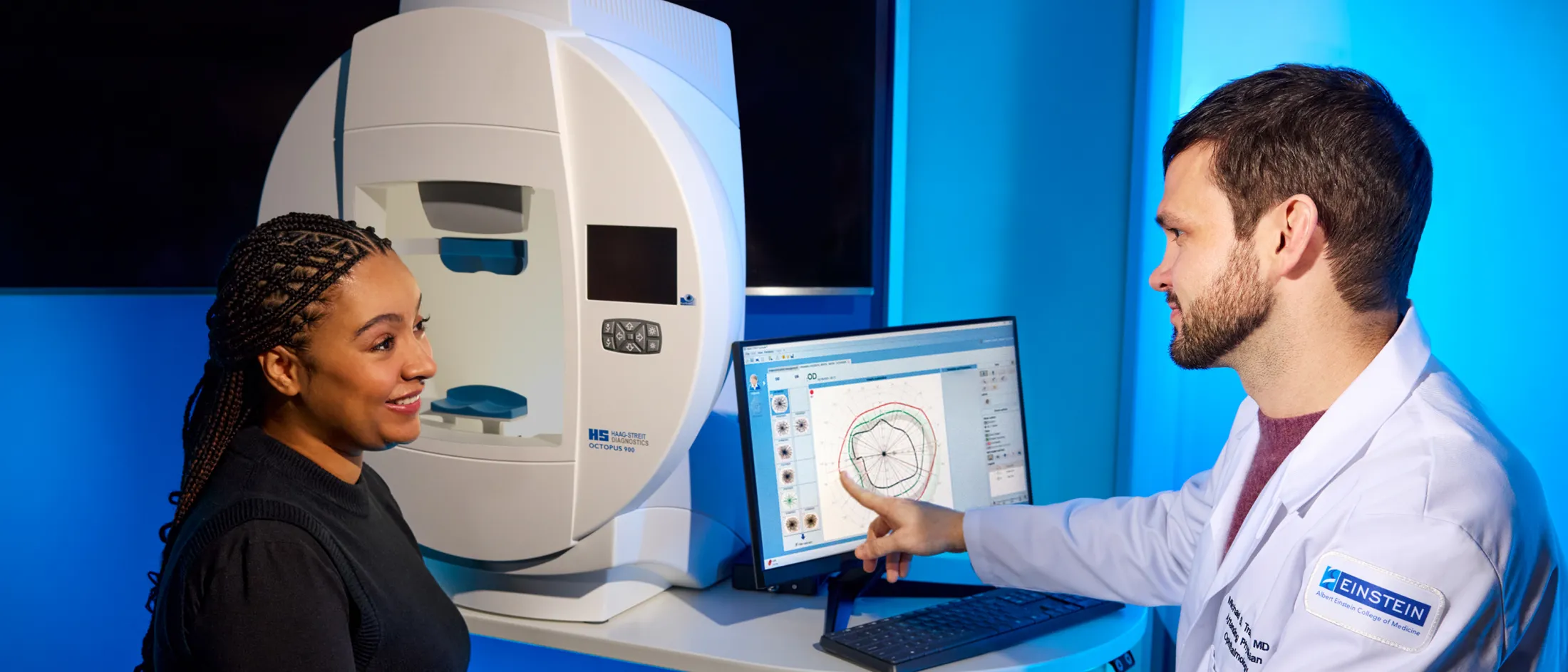 Ophthalmologist sitting with a patient and reviewing details on a screen