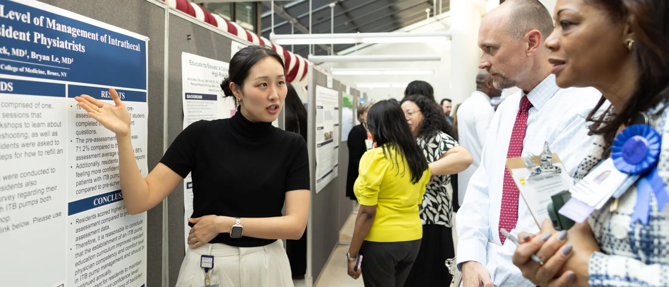 Woman presenting a research poster to a group at a conference