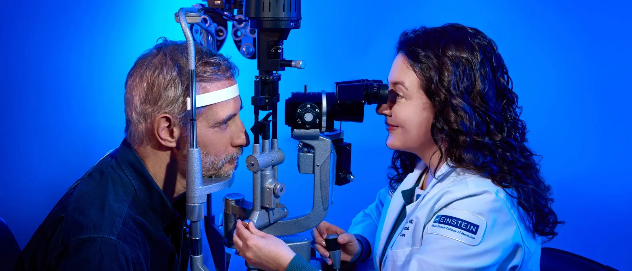 An ophthalmologist gives an eye exam to a patient