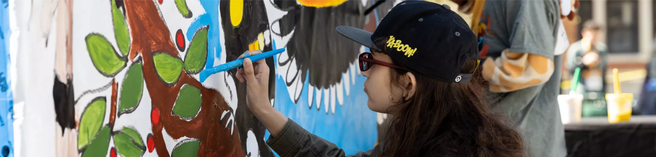 A young adult painting on a wall