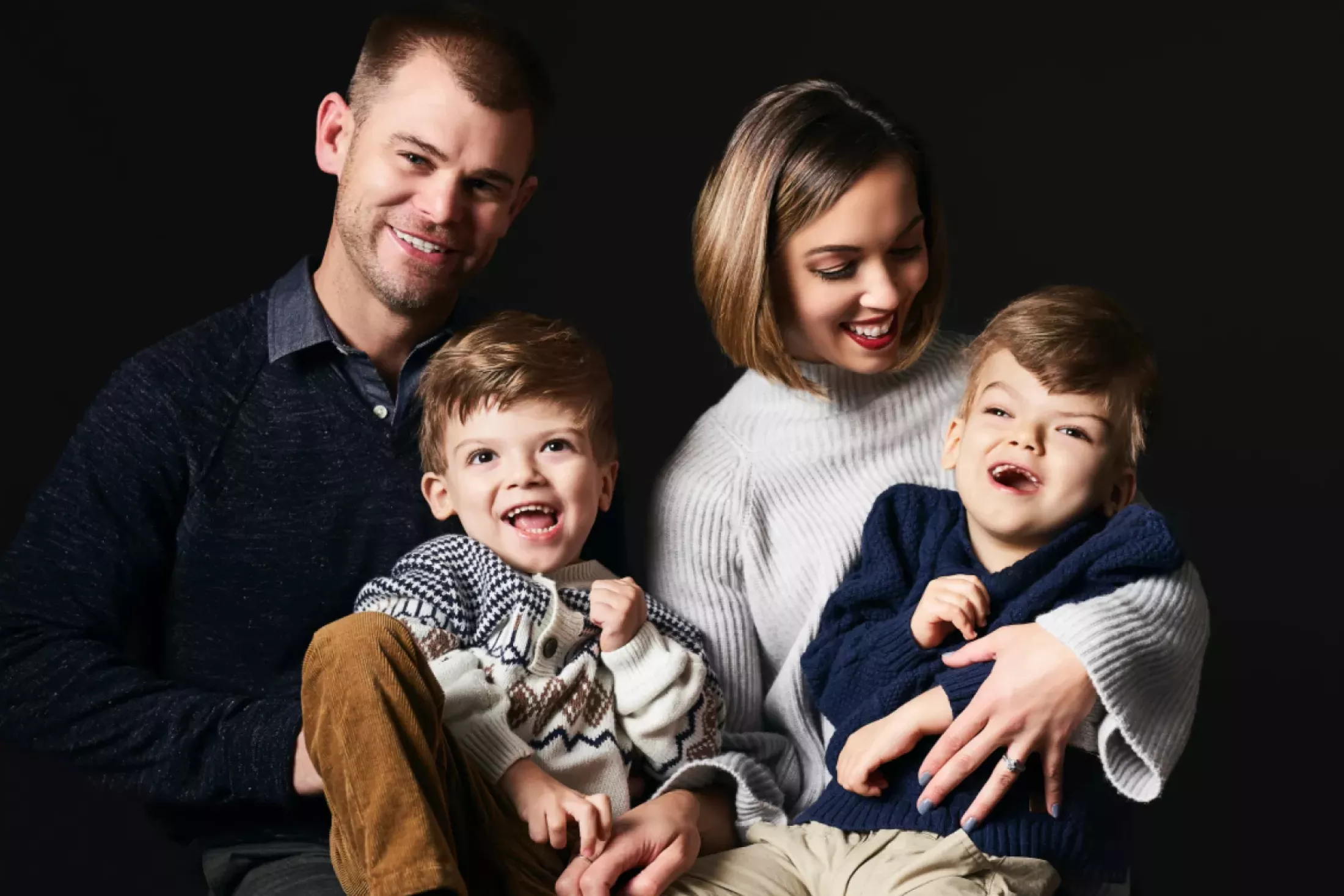 Mom and Dad holding Anias and Jadon laughing