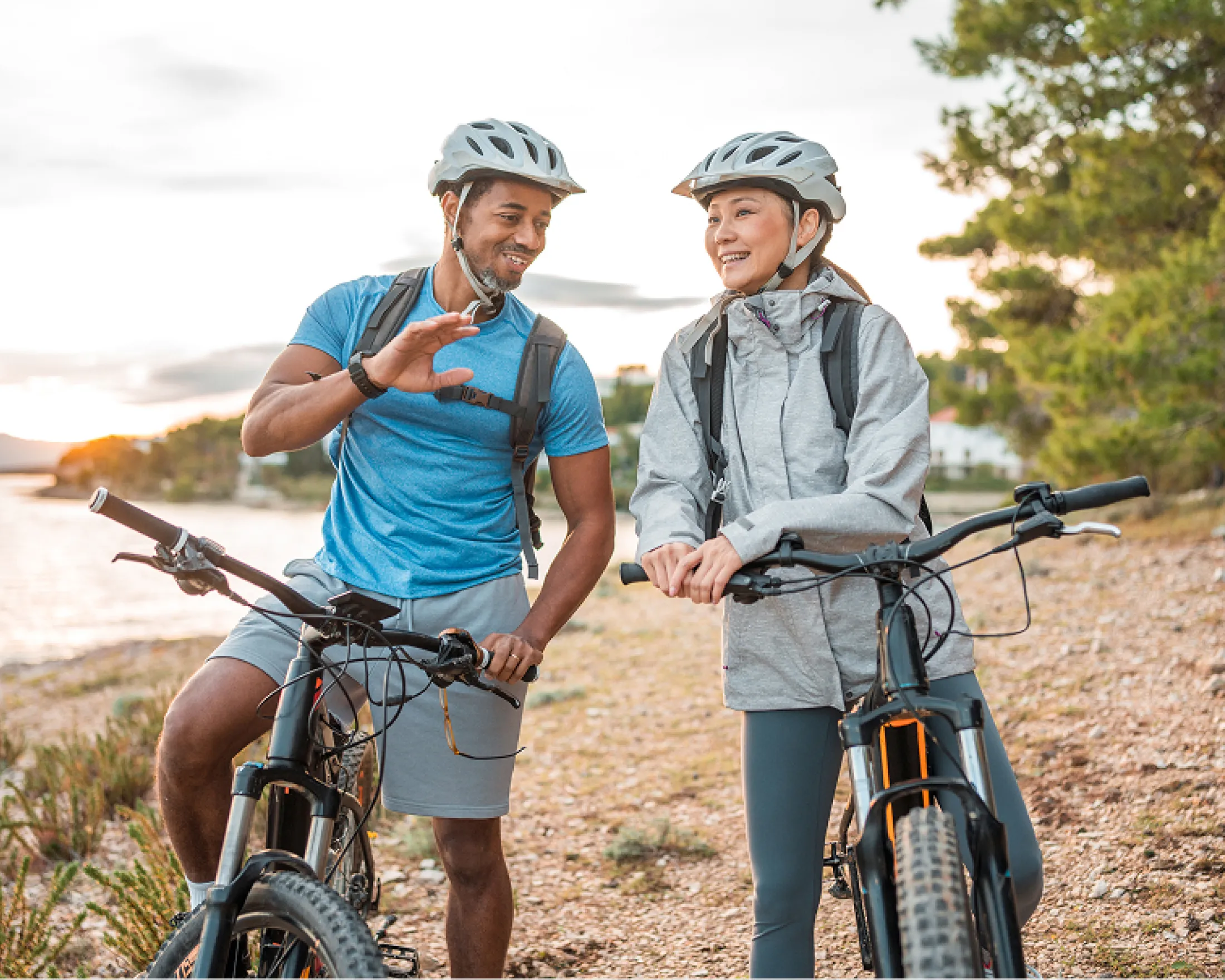 A man and a woman sitting on their mountain bikes