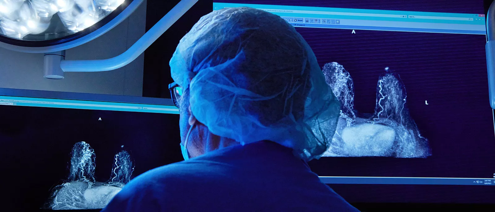 Medical professional in a dimly lit room using state-of-the-art medical technology in an operating room.