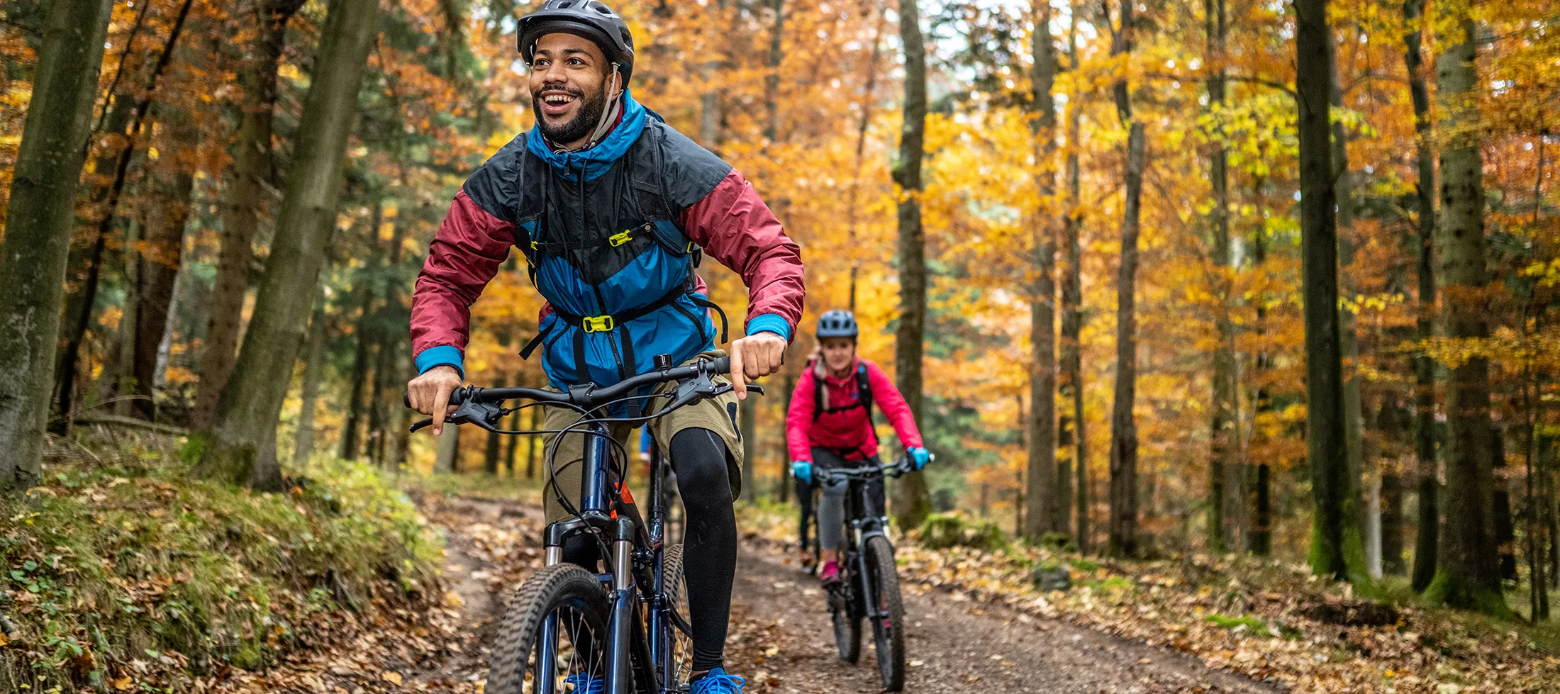 Man and woman riding mountain bikes in forest