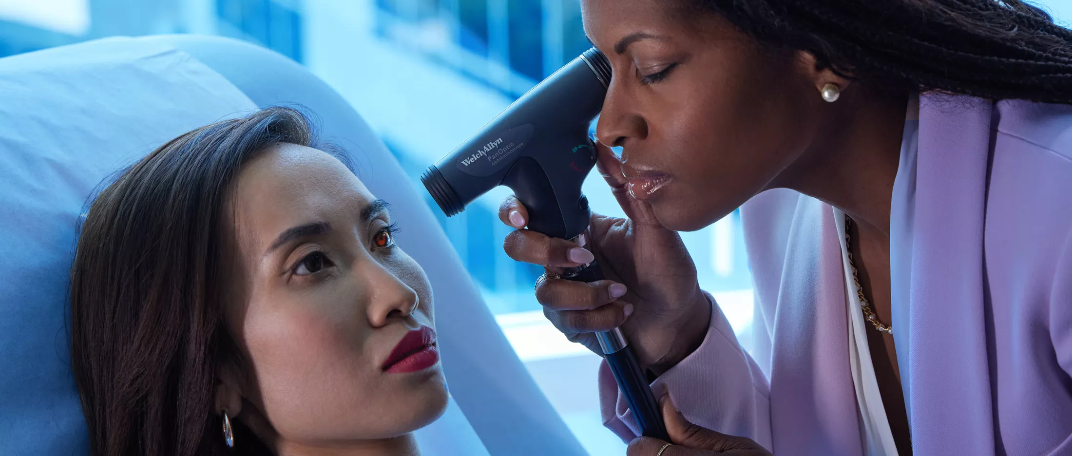 A physician using an ophthalmoscope on a patient