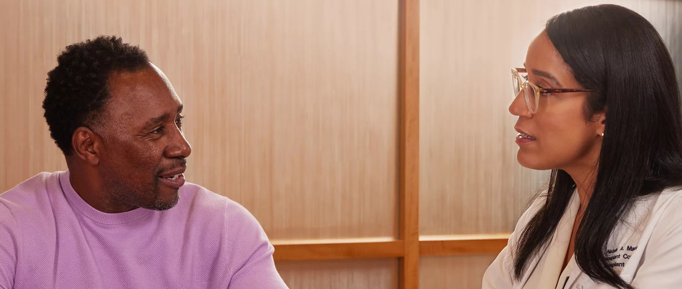 A transplant coordinator talking with a patient inside an office