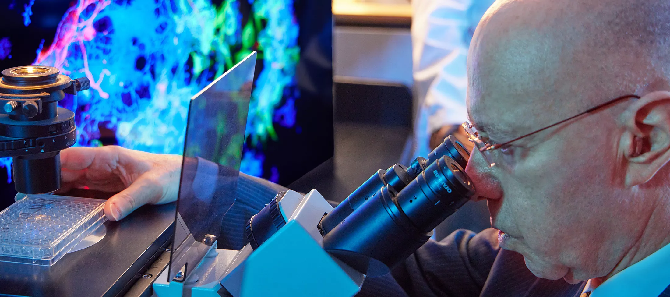 A physician looking into a microscope 